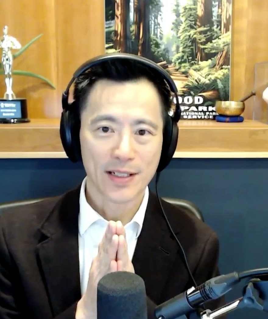 David Niu recording an interview, wearing headphones at a studio microphone.